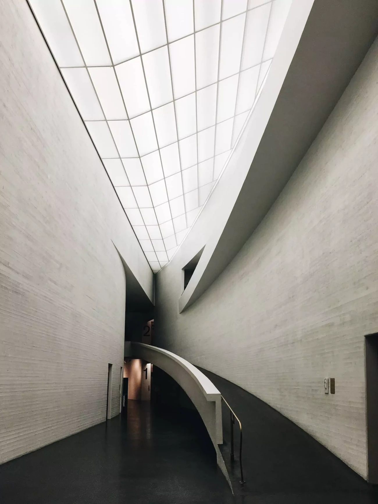 Eine Rampe entlang einer gebogenen Wand im Kiasma-Museum, Helsinki, Finnland